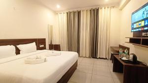a hotel room with a bed and a flat screen tv at Hotel Tapovanam Rishikesh in Rishīkesh