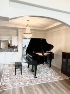 a black piano in a room with a kitchen at Master Bedroom with Two Queen Sized Bed in Richmond