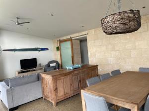 ein Wohnzimmer mit einem Holztisch und einem TV in der Unterkunft Margaret River Beach Houses in Gnarabup