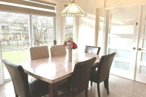 a dining room table with chairs and a vase with flowers at Master Bedroom with Two Queen Sized Bed in Richmond