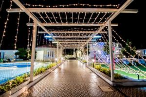 un ponte sopra una piscina di notte con luci di CSR Landmark Resorts a Coimbatore