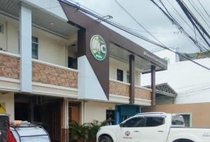 Bayombong的住宿－RedDoorz @ Capitol View MC Inn Nueva Vizacaya，停在大楼前的白色卡车