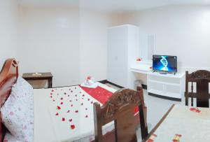 a room with a table and a bed with hearts on it at RedDoorz @ Capitol View MC Inn Nueva Vizacaya in Bayombong