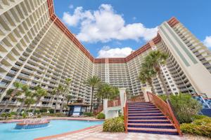 a large resort building with a swimming pool and palm trees at Shores Of Panama 1403 in Panama City Beach