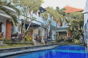 a house with a swimming pool in front of a house at The Green Home Bali in Denpasar