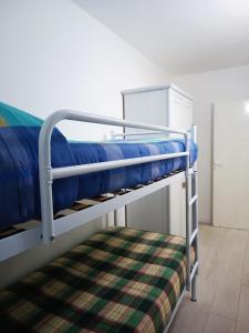 a bunk bed with blue sheets and a plaid blanket at Il Vantaggio in Bagnoregio