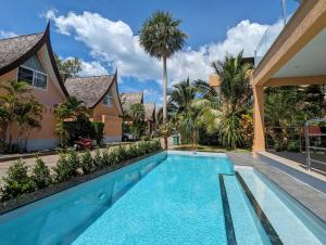 ein Swimmingpool vor einem Haus mit Palmen in der Unterkunft Koh Chang Pool Villa - by KohChangVillas in Ko Chang