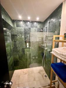 een badkamer met een douche en een glazen deur bij Beachfront Hammock Heaven in Akumal