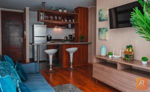 een woonkamer met een keuken en een bar met krukken bij Arrendamiento Peru in Lima