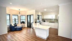 a kitchen and living room with a counter and a table at Perfect North Brisbane Retreat 4 bed in Griffin