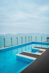 een zwembad met de oceaan op de achtergrond bij Arrendamiento Peru in Lima