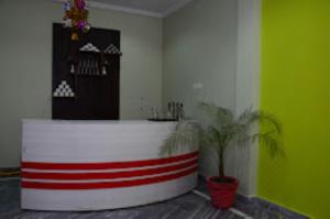 Zimmer mit einer roten und weißen Theke mit einer Pflanze in der Unterkunft The Lord Hotel,Chandrapura in Chhatarpur
