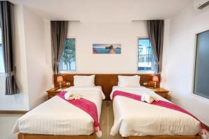 twee bedden in een kamer met ramen bij Horizon Beach Resort Koh Jum in Ko Jum