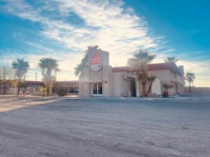 a large building with palm trees in front of it at Happy Smart Inn I-10 Eloy and Casa Grande in Eloy