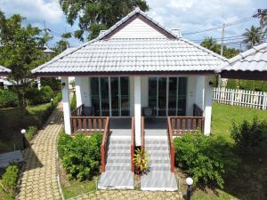 une petite maison avec 2 chaises et une terrasse couverte dans l'établissement Horizon Beach Resort Koh Jum, à Ko Jum