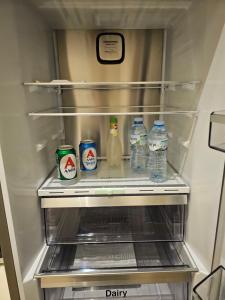 una nevera llena de botellas de leche y agua en Elektras Apartment στο κέντρο της Λάρισας με δωρεάν πάρκιγκ, en Larisa