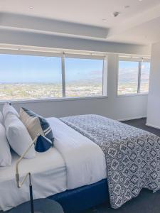 a bedroom with a bed and a large window at Sub-Penthouse on Gloucester - Highest rental in the South Island in Christchurch