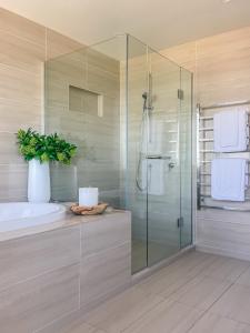 a bathroom with a glass shower and a tub at Sub-Penthouse on Gloucester - Highest rental in the South Island in Christchurch