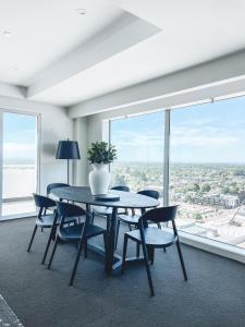 mesa y sillas en una habitación con ventana grande en Sub-Penthouse on Gloucester - Highest rental in the South Island, en Christchurch