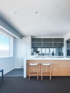 a kitchen with two chairs and a kitchen island at Sub-Penthouse on Gloucester - Highest rental in the South Island in Christchurch