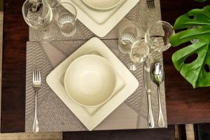 基利菲的住宿－TAUSI HOMES Sultan Palace Beach Resort，一张桌子,上面有盘子、叉子和酒杯