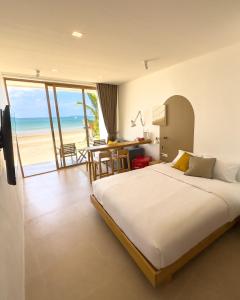a bedroom with a bed and a view of the beach at lovelytheroom in Ko Lanta