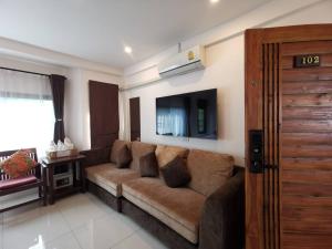 uma sala de estar com um sofá e uma televisão de ecrã plano em Sasima House em Chiang Mai