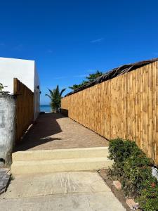 a wooden fence next to a sidewalk next to the ocean at lovelytheroom in Ko Lanta