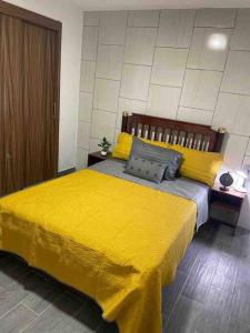 1 dormitorio con 1 cama amarilla con sábanas amarillas en Casa Rose Gold, en Guadalajara