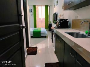 uma cozinha com um lavatório e uma cama num quarto em Jenny N Rose Travellers Inn em Manila