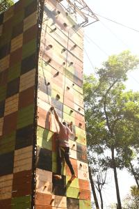 a man is on a climbing wall on a building at Z-Bac Adventure & Leisure Resort Kolad in Kolād