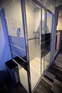 a glass shower in a room with a trash can at Studio indépendant Pa Ni Pwoblem in Vitrolles