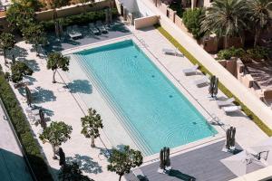 an overhead view of a swimming pool with chairs and trees at Stunning Burj Royale Residence Downtown Dubai - Burj Khalifa in Dubai