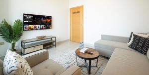 a living room with a couch and a table at HomesGetaway - Stylish 1BR Armada Cluster P in Dubai