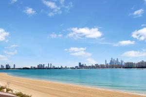 - une vue sur une plage avec une ville en arrière-plan dans l'établissement FAM Living - Palm Jumeirah - Beach Villas with Private Pool, à Dubaï