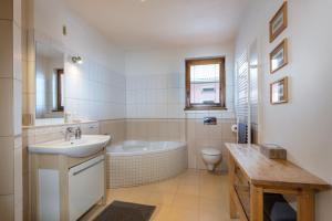 a bathroom with a sink and a tub and a toilet at Pension Iveta in Liptovský Mikuláš