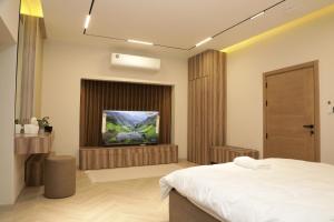 a bedroom with a bed and a flat screen tv at Moon mountain villa 