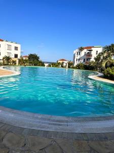 una gran piscina de agua azul con edificios al fondo en TAUSI HOMES Sultan Palace Beach Resort en Kilifi