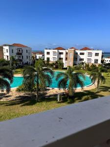Blick auf einen Pool mit Palmen und Gebäuden in der Unterkunft TAUSI HOMES Sultan Palace Beach Resort in Kilifi