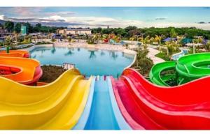 un grand parc aquatique avec un toboggan aux couleurs arc-en-ciel. dans l'établissement Astoria Palawan, à San Jose