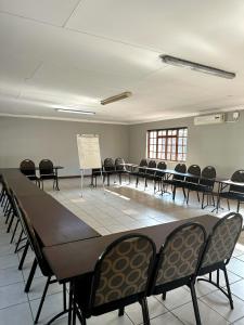a conference room with a large table and chairs at The Hempel Guesthouse in Mokopane