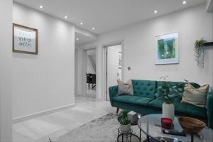 ein Wohnzimmer mit einem grünen Sofa und einem Tisch in der Unterkunft LiveStay-Modern & Stylish Apartments in Didcot in Didcot