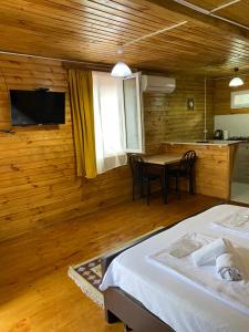 a bedroom with a bed and a table with chairs at Wooden Cottages - Mtskheta in Mtskheta