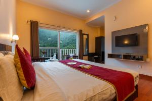 a bedroom with a large bed and a television at Hotel Vista Bhowali, Nainital - Vegetarian in Bhowāli