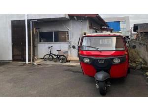a small red scooter parked in front of a garage at guest house goose - Vacation STAY 23621v in Hirosaki