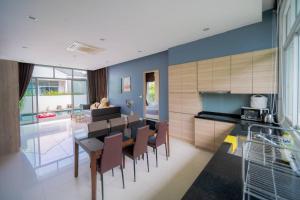 a kitchen and dining room with a table and chairs at บีชทาวน์ ชะอำ พูลวิลล่า ห่างหาดชะอำ2กม Beach town cha-am poolvilla from Cha-Am beach just 2km in Cha Am