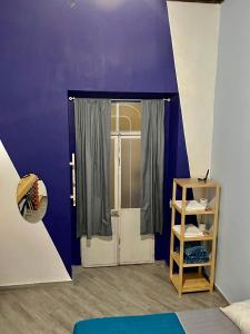 una habitación con una pared púrpura y una puerta en Céntrica habitación privada , #7 de 1 a 4 personas, Casona Doña Paula Aparta-hotel, baño compartido en Puebla