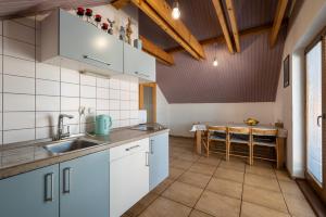 a kitchen with white cabinets and a sink and a table at Pension Iveta in Liptovský Mikuláš +20 photos