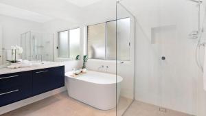 a white bathroom with a sink and a shower at Forest Brae in Bundanoon