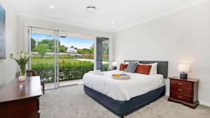 a bedroom with a large bed and a large window at Forest Brae in Bundanoon